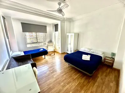 a bedroom with a blue bed and a couch at Rooms Valencia Center in Valencia