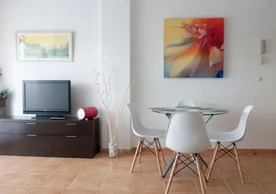 a dining room with a table and chairs and a tv at Apartamento Playa Moncofar - Xilxes in Moncófar