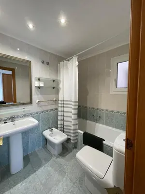 a bedroom with a bed with a pair of shoes on it at Fantastico bajo con Jardin en Playa de Canet in Canet de Berenguer