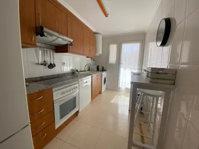 a bedroom with a bed with a colorful striped blanket at Fantastico bajo con Jardin en Playa de Canet in Canet de Berenguer