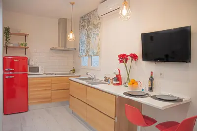 a kitchen with a red refrigerator and red chairs at COZY & MODERN Apartment junto a Metro A Guimerá in Valencia