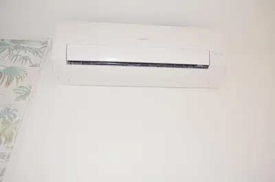 a white air conditioner on a wall next to a bed at COZY & MODERN Apartment junto a Metro A Guimerá in Valencia