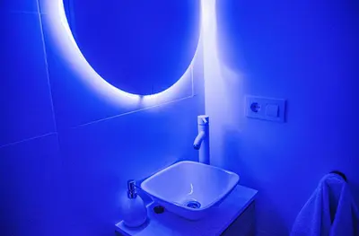 a blue bathroom with a sink and a blue light at COZY & MODERN Apartment junto a Metro A Guimerá in Valencia