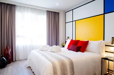 a bedroom with a large white bed with red pillows at Voghe Premium Flats in Valencia