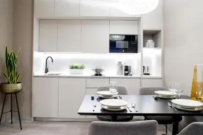 a kitchen with white cabinets and a table and chairs at Voghe Premium Flats in Valencia