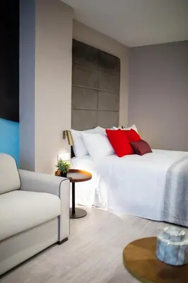 a bedroom with a bed with red pillows and a table at Voghe Premium Flats in Valencia