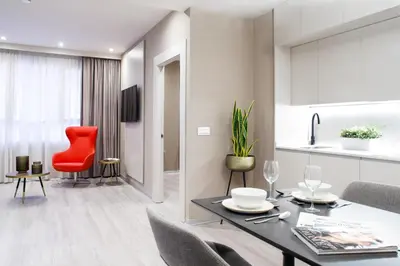 a living room with a table and a red chair at Voghe Premium Flats in Valencia