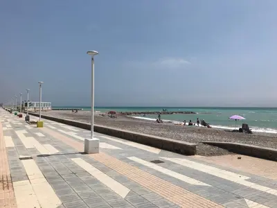 a beach with people sitting on the sand and the ocean at Apartamento Playa Grau Moncofa in Moncófar