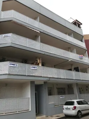 a building with white balconies and a car parked in front at Apartamento Playa Grau Moncofa in Moncófar