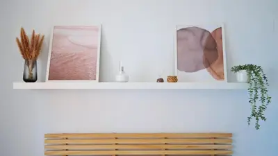 a white shelf with three pictures and a wooden bench at LUJOSO apartamento- PLAYA Canet Berenguer in Canet de Berenguer