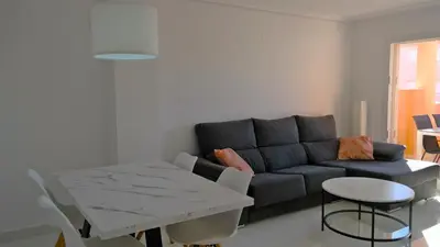 a living room with a couch and a table at LUJOSO apartamento- PLAYA Canet Berenguer in Canet de Berenguer
