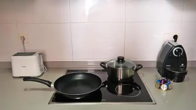 a kitchen stove with two pots and pans on it at LUJOSO apartamento- PLAYA Canet Berenguer in Canet de Berenguer