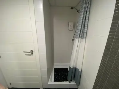 a bathroom with a shower with a door with a drain at LUJOSO apartamento- PLAYA Canet Berenguer in Canet de Berenguer
