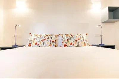 a bedroom with a white bed with two lamps at Central Station. Free Wifi & Terrace in Valencia