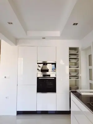 a kitchen with white cabinets and a black oven at The White Apartment: Luxury, Beach and Design in Valencia