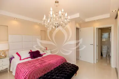 a bedroom with a large bed and a chandelier at The White Apartment: Luxury, Beach and Design in Valencia