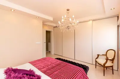 a bedroom with a bed and a chandelier at The White Apartment: Luxury, Beach and Design in Valencia