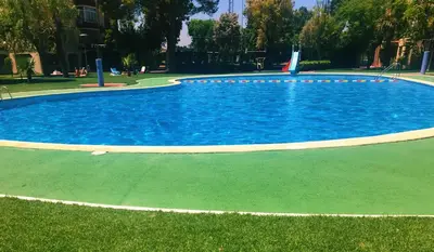 a large pool with blue water in a park at The White Apartment: Luxury, Beach and Design in Valencia