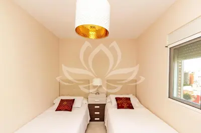 a room with two beds and a large flower on the wall at The White Apartment: Luxury, Beach and Design in Valencia