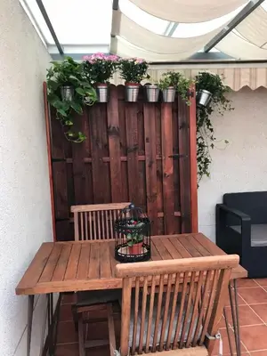 a wooden table with potted plants on a fence at Habitación en Casa Qerétaro in Silla