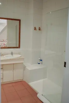 a bathroom with a glass shower and a sink at Casa Modernista 