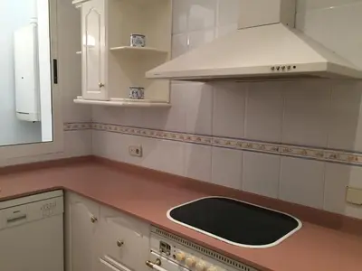 a white kitchen with a sink and a stove at Casa Modernista 