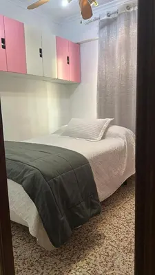 a bedroom with a bed and pink cabinets at Alquiler universidades malvarrosa Playa Maritim Valencia in Valencia