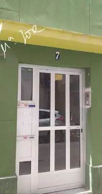 a green building with a door with a sign above it at Alquiler universidades malvarrosa Playa Maritim Valencia in Valencia