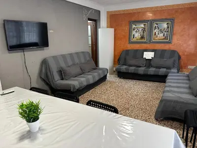 a living room with two couches and a flat screen tv at Alquiler universidades malvarrosa Playa Maritim Valencia in Valencia
