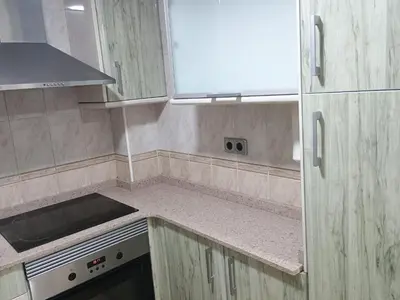 a small kitchen with white cabinets and a stove at Alquiler universidades malvarrosa Playa Maritim Valencia in Valencia