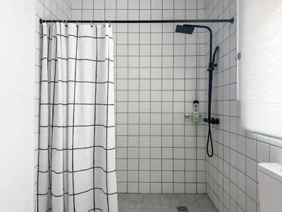 a shower with a shower curtain in a bathroom at Apartamentos Navío in Valencia