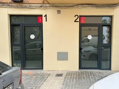 two doors on the side of a building with parked cars at Apartamentos Navío in Valencia
