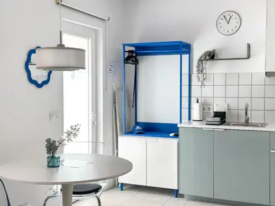 a kitchen with a table and a clock on the wall at Apartamentos Navío in Valencia
