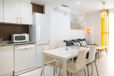 a kitchen and dining room with a white table and chairs at Hideout 26 in Valencia