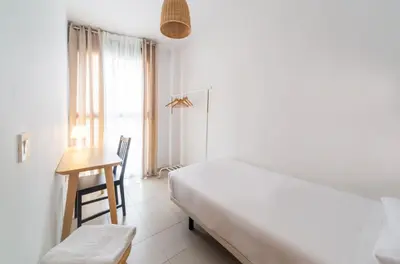 a bedroom with a bed and a desk and a window at Hideout 26 in Valencia