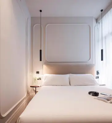 a bedroom with a white bed with a large window at Room Mate Oliveira - City Centre, Valencia in Valencia