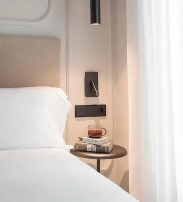 a bedroom with a bed and a side table with a bowl at Room Mate Oliveira - City Centre, Valencia in Valencia