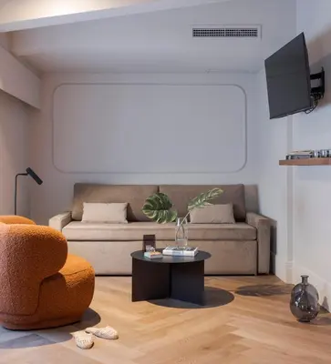 a living room with a couch and a table at Room Mate Oliveira - City Centre, Valencia in Valencia