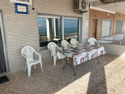 a table and chairs on a patio with a view of the ocean at Broadway es Mar in El Perelló