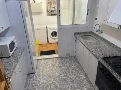 a small kitchen with a sink and a microwave at Broadway es Mar in El Perelló