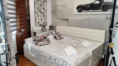 a bedroom with a white bed with a black car on the wall at Terrasa de Mercado Central in Valencia