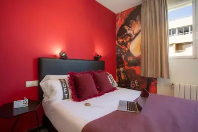 a red bedroom with a bed with a laptop on it at Casual del Cine Valencia in Valencia
