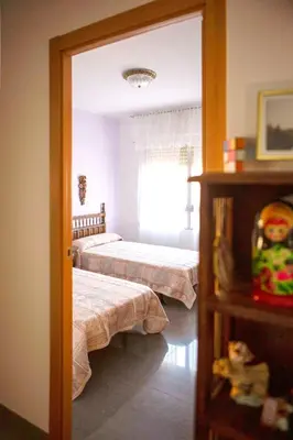a bedroom with two beds and a mirror at Bonito apartament a 3 minutos de la playa in Cullera