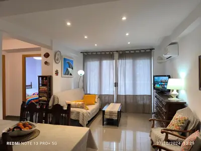 a living room with a couch and a tv at Bonito apartament a 3 minutos de la playa in Cullera