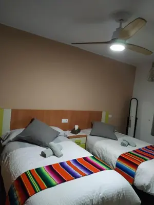 a bedroom with two beds and a ceiling fan at Bonito apartament a 3 minutos de la playa in Cullera