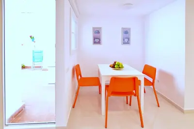 a dining room with a white table and orange chairs at Emma Apartment Central in Valencia