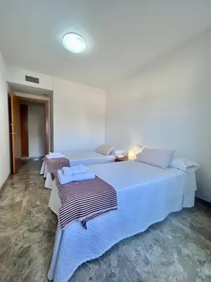 a white bedroom with two beds with towels on them at NEW! Apartamento Ciudad de las Artes in Valencia