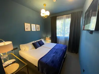 a bedroom with a bed with blue sheets and a window at Hografic Hotel in Valencia