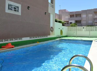 a swimming pool in the middle of a building at Global Vacacional, Apartamento 2 dormitorios en Canet d'en Berenguer in Canet de Berenguer
