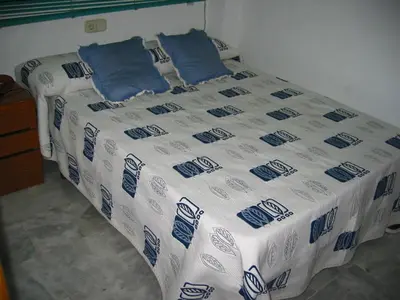 a bed with blue and white sheets and pillows at CANAL SALINAS Solo Familias Serviplaya in Casas Las Basas